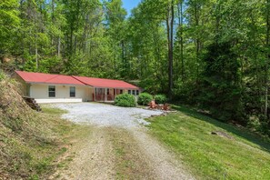A house with a red roof, surrounded by a forest. - Baskins Creek 406 (Gatlinburg)