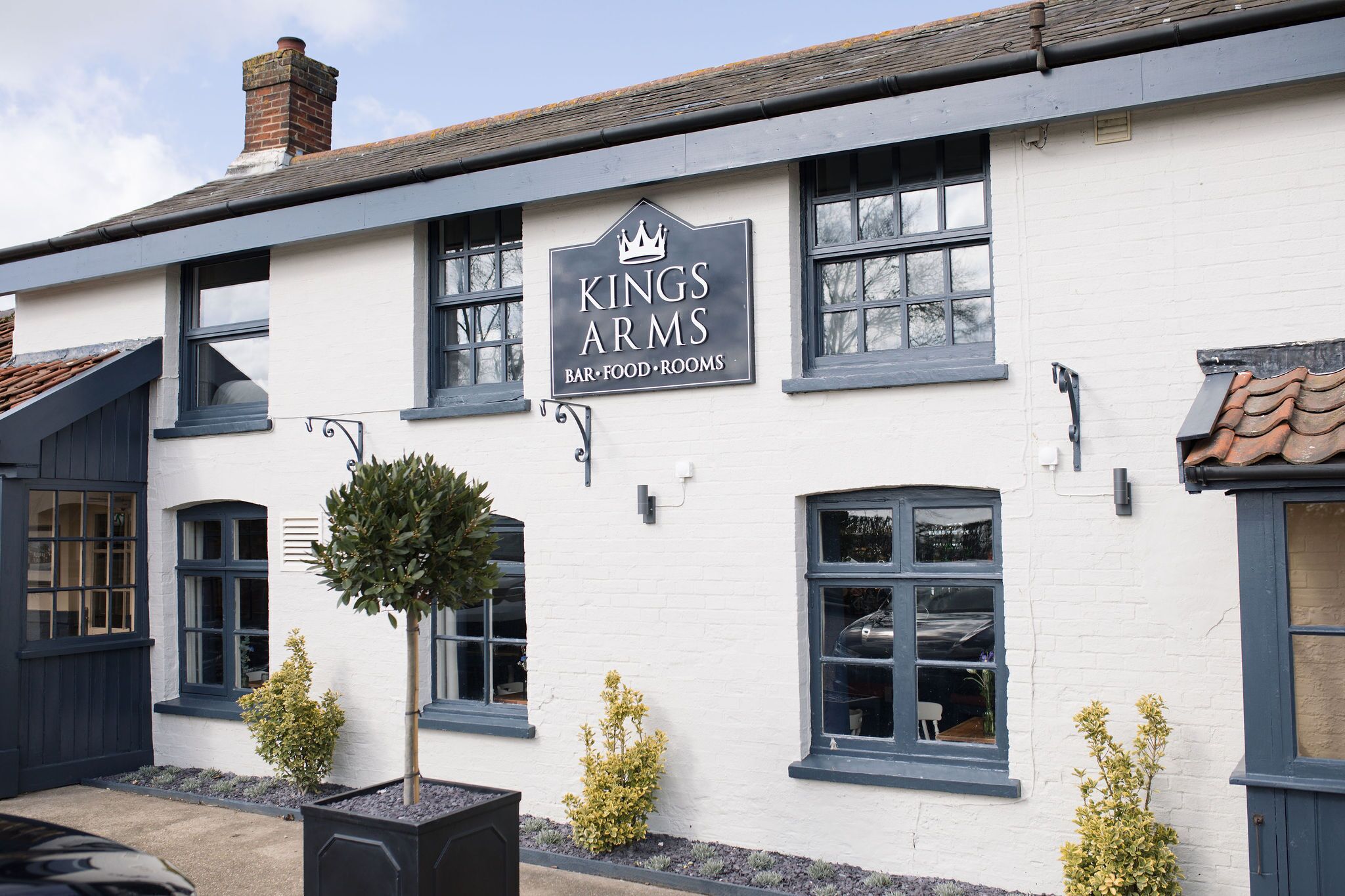 En byggnad med en skylt som visar texten ”Kings Arms Bar – matservering”.