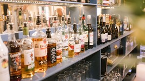 Estantes repletos de botellas de licor y vasos.
