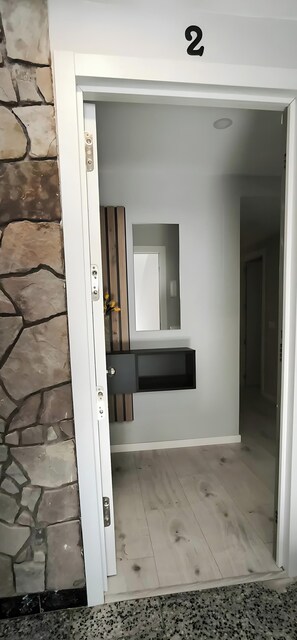 A doorway with a stone wall, a number '2' above it, and a mirror on the wall. - Apartment 'Golden Sky 3ª' with Shared Terrace, Wi-Fi and Air Conditioning (Benicarló)