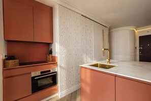 A modern kitchen with a built-in oven, a sink with a gold faucet, and a patterned backsplash. - Refined Apartment in Sevilles Historic Centre. General Castaños (Seville)