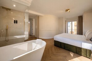 A modern bedroom with a large bathtub, a bed with a green upholstered headboard, and a large window with curtains. - Refined Apartment in Sevilles Historic Centre. General Castaños (Seville)