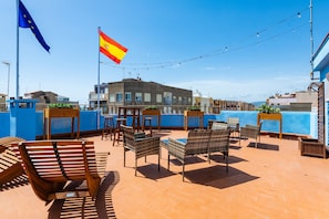 Une terrasse sur le toit avec des sièges en plein air, une piscine et des drapeaux.