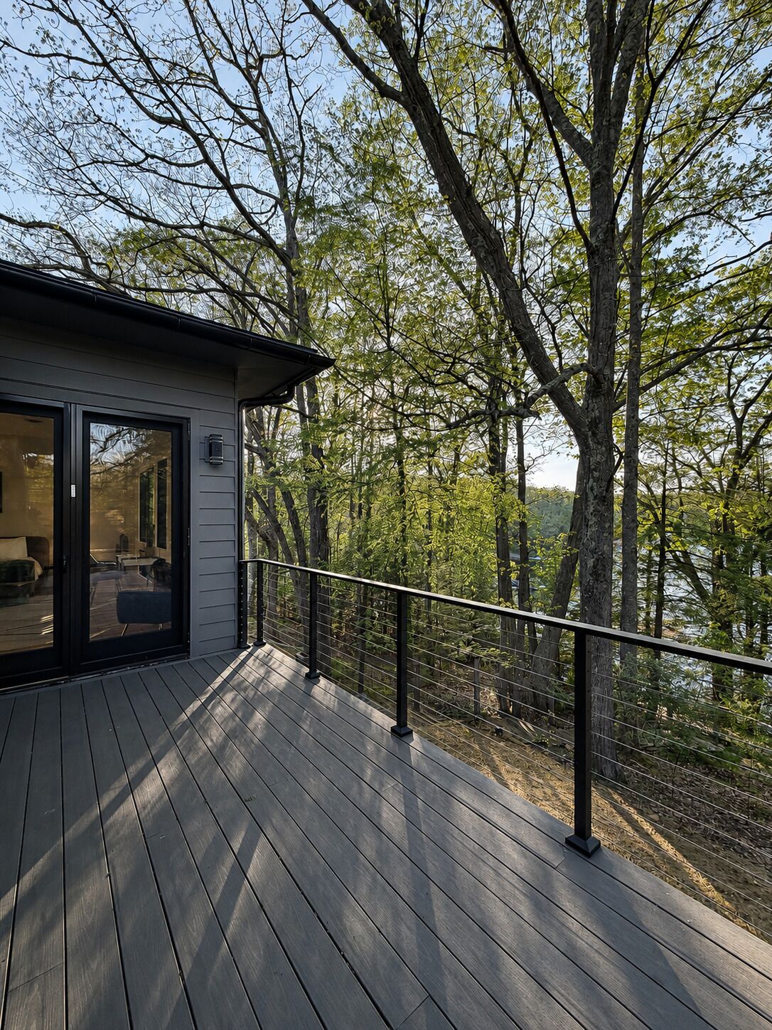 A deck with a railing overlooking a forested area.