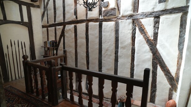 A room with exposed timber framing, a wooden staircase, a chandelier, and a small basketball. - Charming 3 Bed/2 Bath House in Medieval Village (Tillac)