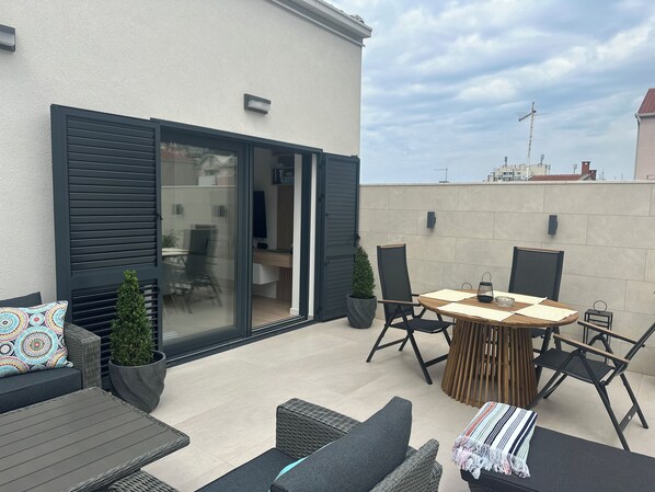 A modern outdoor patio with a dining table, chairs, and a sofa. - Adriatic Sanctuary: Town Center (Makarska)