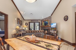 A dining area with a wooden table, chairs, a pumpkin centerpiece, and a fireplace. - Baskins Creek 510 (Gatlinburg)