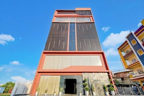 Ein mehrgeschossiges Gebäude mit einem markanten Eingang, großen Fenstern und einem modernen architektonischen Design.