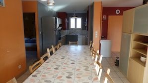 A compact kitchen with a dining area, a refrigerator, and a sink.