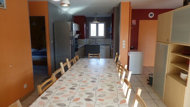 A compact kitchen with a dining area, a refrigerator, and a sink.
