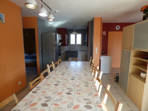 Cocina compacta con comedor, refrigerador y pileta.