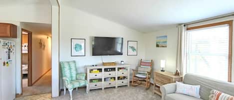 A living room with a sofa, a television, a coffee table, and a bookshelf.