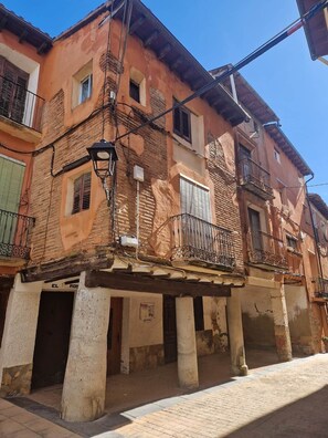A building with a traditional facade, multiple balconies, and a covered entrance area.