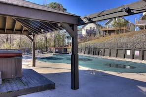 A covered outdoor area with a pool, a hot tub, and a wooden deck. - Mountain View Memories Unit #2102 (Gatlinburg)