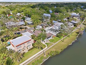 An aerial view of a residential area with houses, a river, and a well-maintained lawn. - Morning Glory Historic Downtown (St. Augustine)