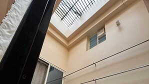 A room with a skylight, a window, and a patterned laundry basket on a cart. - Vardaan Homestay  (Ujjain)