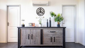 A modern kitchen with a wooden cabinet, a clock, and decorative items on the counter.