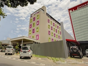 A hotel with a modern facade, multiple windows, and a covered parking area. - Luxury Twin Stay With Free Wifi and Parking (Jakarta)