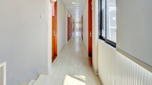 Ein Korridor mit einem Schild, das einen Ausgang weist, einem Fenster rechts und einer Tür links.