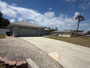 Una propiedad residencial con garaje, entrada para vehículos y césped.