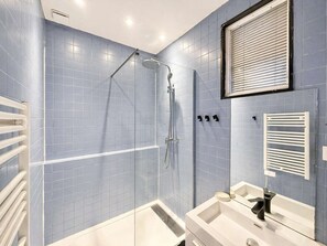 Ein Badezimmer mit Dusche, Badewanne, Waschbecken und Spiegel.