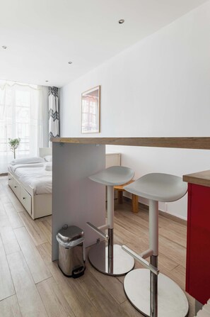 Ein modernes Schlafzimmer mit einem Bett, einem Nachttisch und einer kleinen Mülleimer.