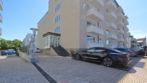 Ein mehrgeschossiges Wohngebäude mit Parkplatz.