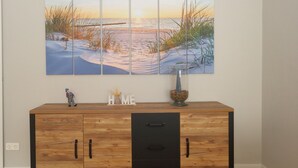 Eine Holzkabine mit drei Schubladen, einer Dekofigur und einer Vase mit getrockneten Pflanzen.