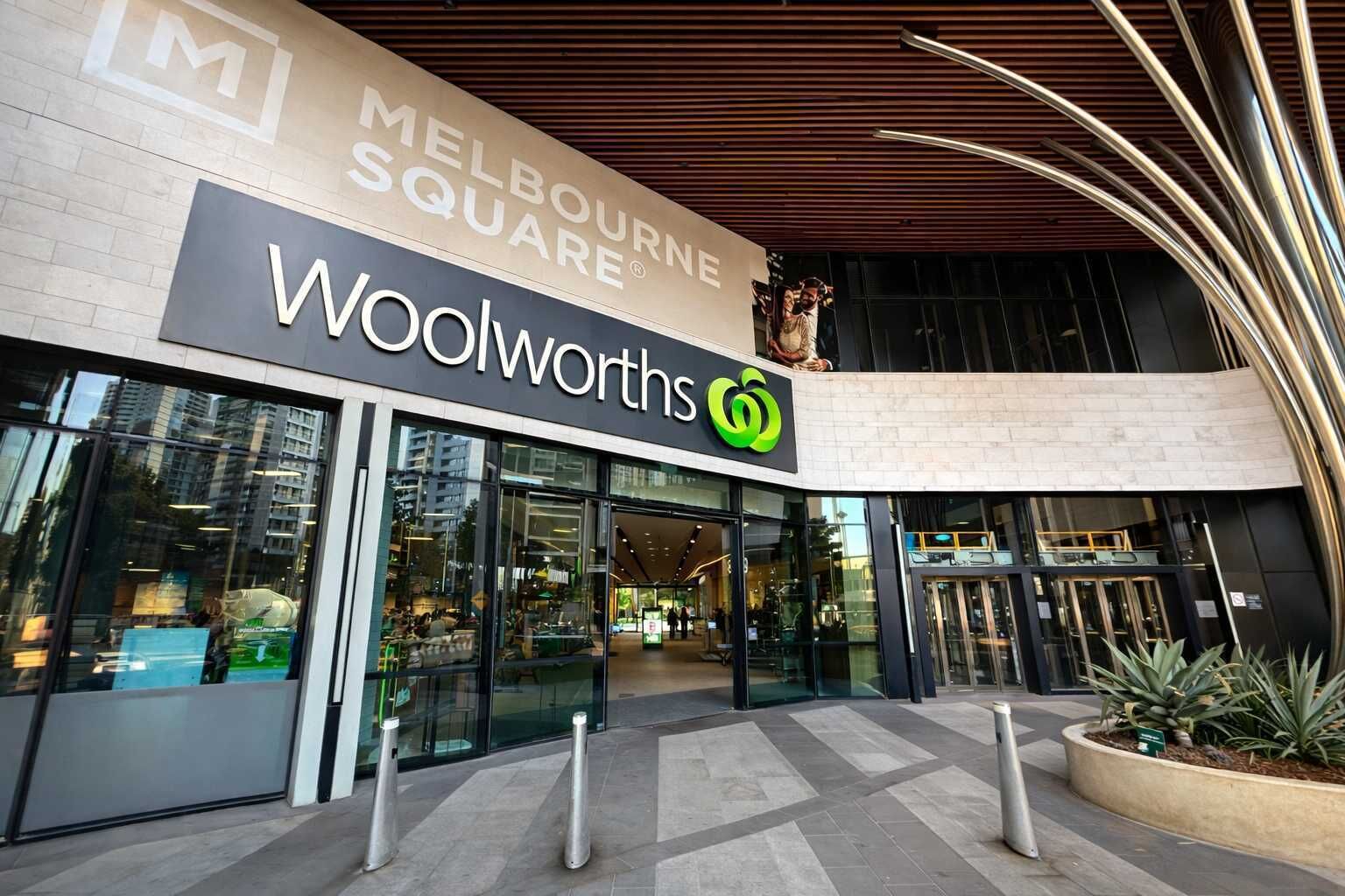 A Woolworths store with a modern facade, large glass windows, and a prominent sign.