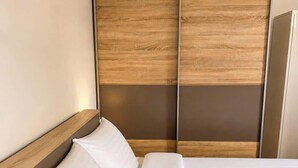 Ein Hotelzimmer mit einem Bett, einem Holzkopfstück und einem großen Spiegel.