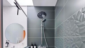 Ein modernes Badezimmer mit Dusche, Waschbecken und Spiegel.