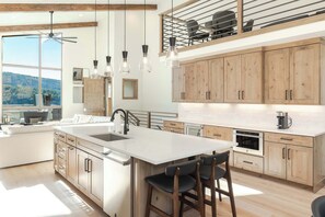 A modern kitchen with a large island, wooden cabinets, and pendant lighting. - First Tracks. Luxury Ski Estate & Rooftop Sauna (Winter Park)