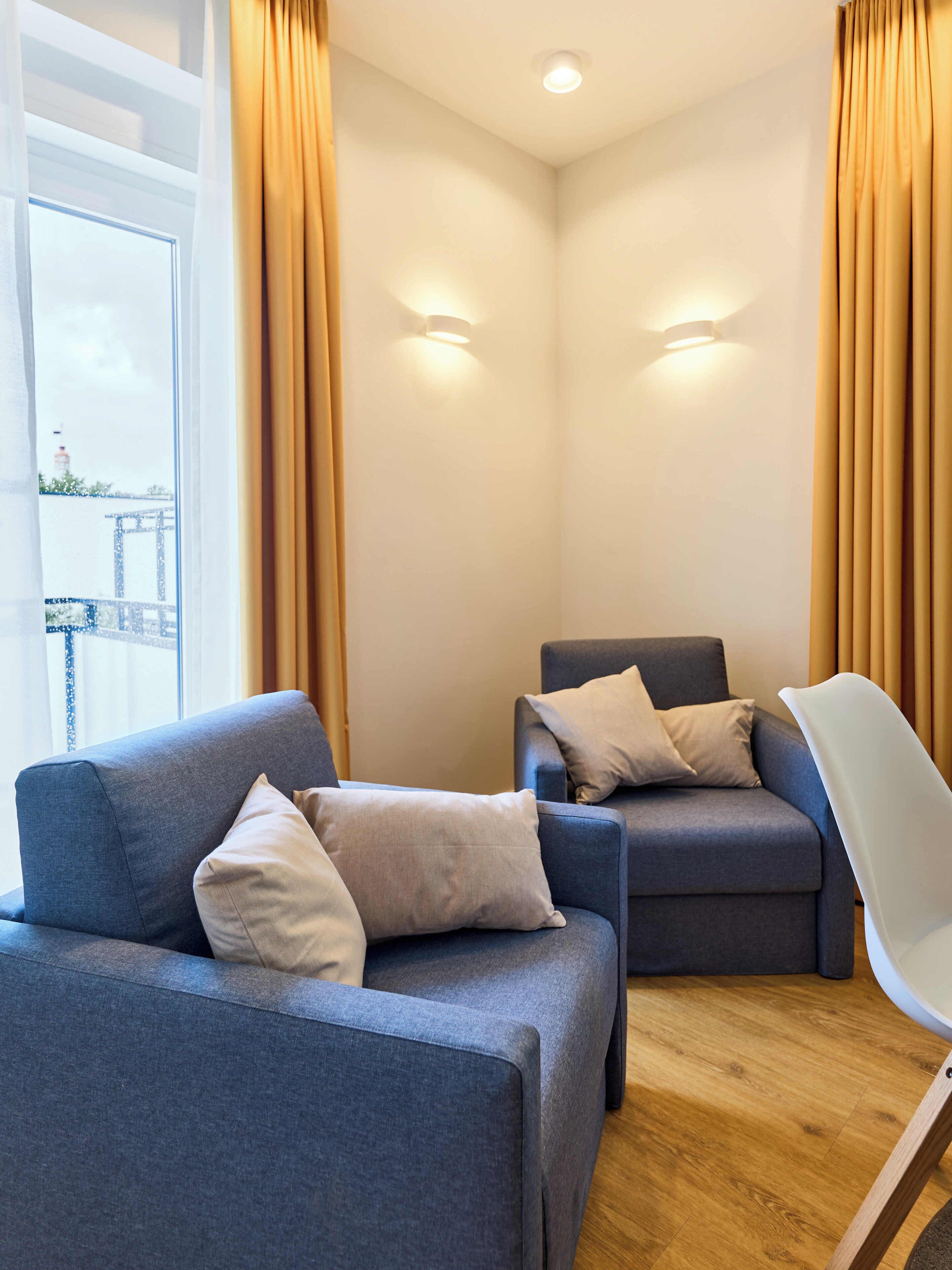 Ein modernes Zimmer mit zwei Sofas, einem Sessel und Blick auf eine Brücke.