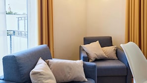 Ein modernes Zimmer mit zwei Sofas, einem Sessel und Blick auf eine Brücke.