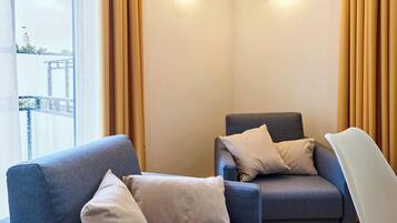 Ein modernes Zimmer mit zwei Sofas, einem Sessel und Blick auf eine Brücke.