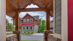 A house with a red roof, a stone porch, and a view of the street. - Mountain High (Gatlinburg)