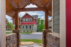 A house with a red roof, a stone porch, and a view of the street. - Mountain High (Gatlinburg)