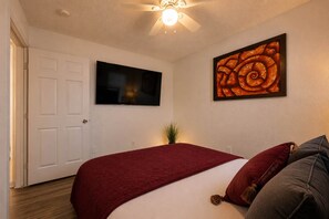 A bedroom with a bed, a television on the wall, and a framed artwork. - Modern Arlington Escape • Stadium 8 Min Away (Arlington)