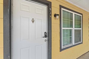 A white door with a brass knocker, a window with a grid pattern, and the number '93' on the wall. - Modern Arlington Escape • Stadium 8 Min Away (Arlington)