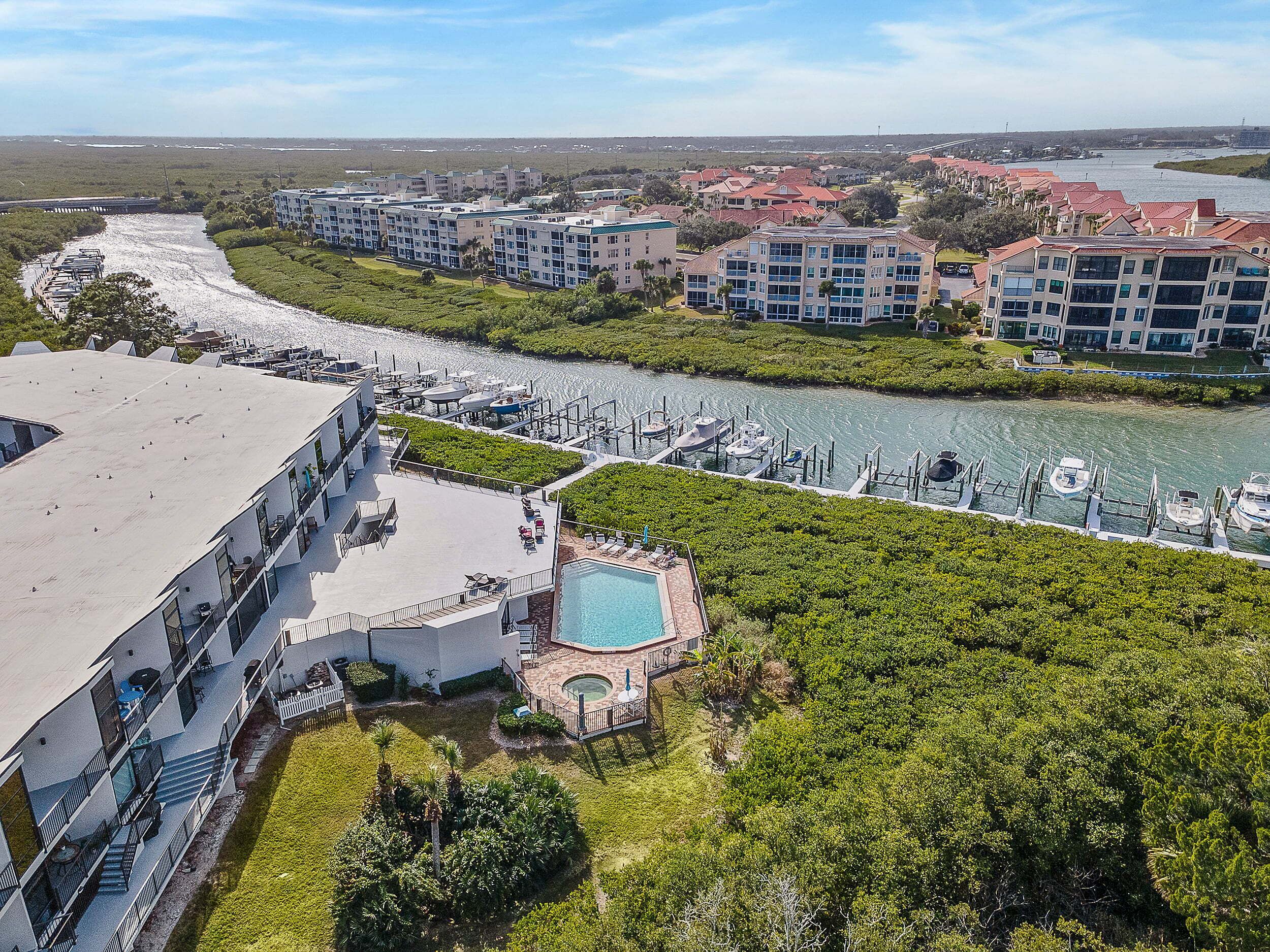 A resort with a swimming pool, marina, and multiple buildings with balconies.