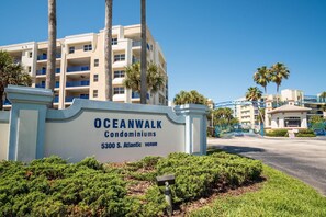 Schild für die Oceanwalk Condominiums in der 5300 S. Atlantic, mit geschlossenem Eingang und Palmen.