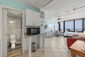 A compact living space with a kitchenette, a bathroom, a dining area, and a balcony with a view. - Hawaiian Inn 332 (Daytona Beach Shores)