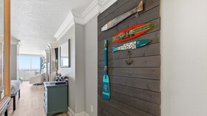 A hallway with a wooden wall, a blue paddleboard, and a fish-shaped decoration. - Daytona Beach Resort 456 (Daytona Beach)