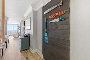 A hallway with a wooden wall, a blue paddleboard, and a fish-shaped decoration. - Daytona Beach Resort 456 (Daytona Beach)