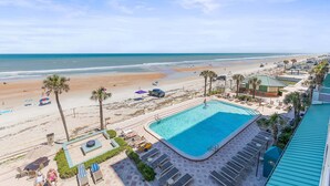 A pool area with lounge chairs, a swimming pool, and a beach view. - Daytona Beach Resort 456 (Daytona Beach)