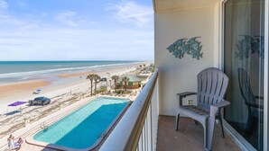 A balcony with a view of a beach, a pool, and a chair. - Daytona Beach Resort 456 (Daytona Beach)