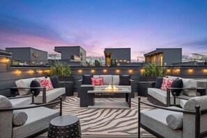 A rooftop lounge with outdoor seating, a fire feature, and string lights. - Rooftop Oasis - Hot Tub, Nashville City Views (Nashville)