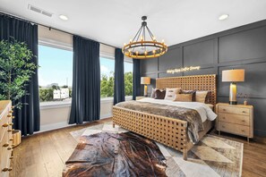 A modern bedroom with a large bed, a chandelier, a view of the city, and a plant. - Rooftop Oasis - Hot Tub, Nashville City Views (Nashville)