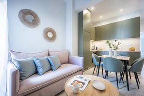 Ein modernes Wohnzimmer mit Sofa, Couchtisch und Essbereich.