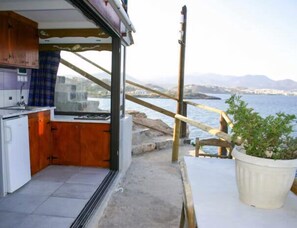 Eine kleine Küche mit Meerblick, einer Holterrasse und einem Blumentopf.